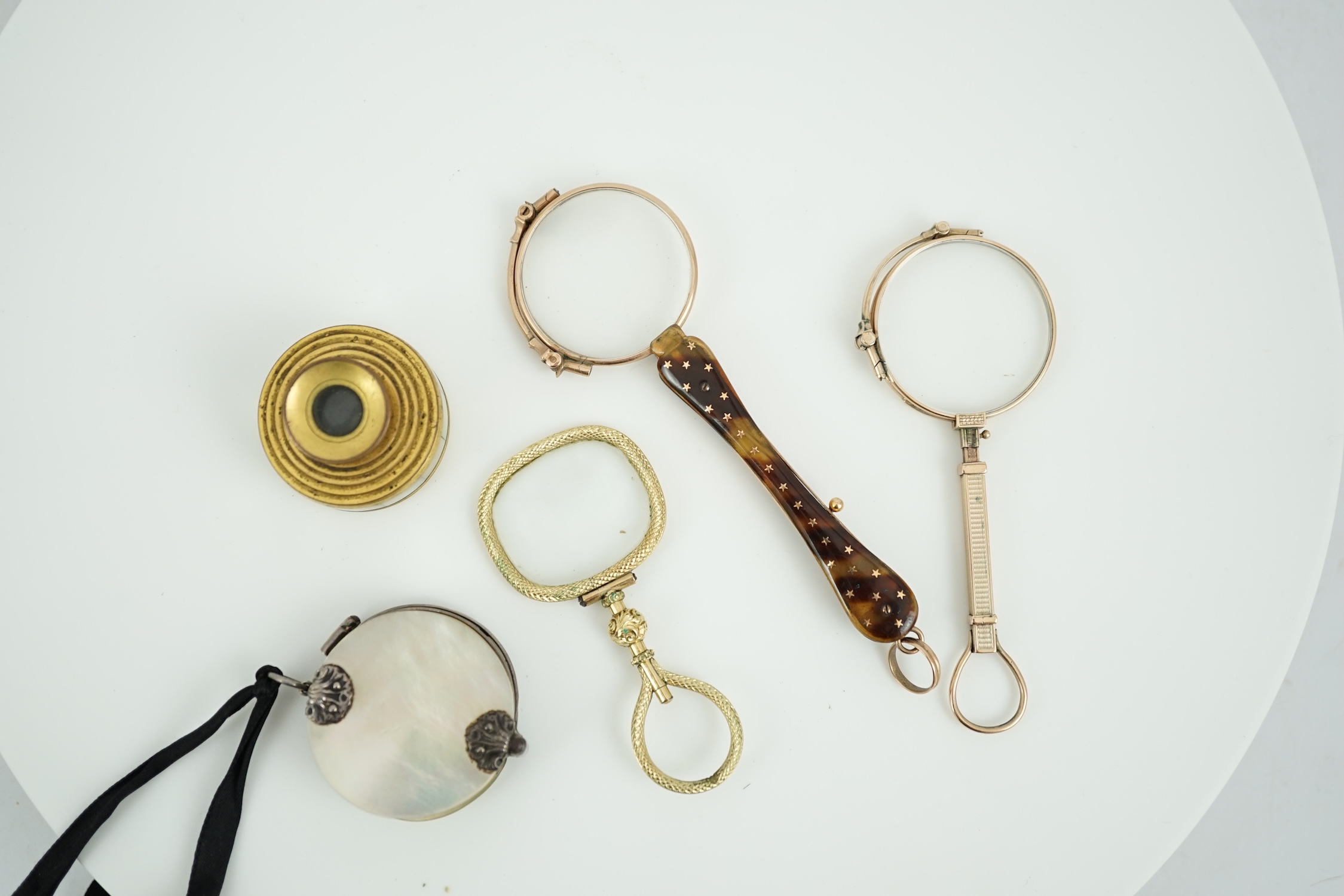 A 19th century mother of pearl and white metal mounted folding double magnifying glass, 40mm, two yellow metal mounted lorgnettes including Hamblin, London, a spy glass and a mother of pearl mounted gilt metal monocular.